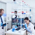 Chemist scientists doing vacine study in busy lab