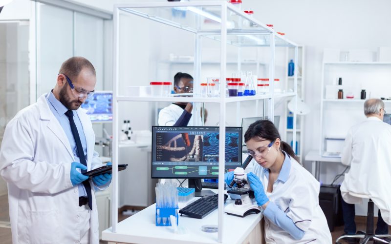 Chemist scientists doing vacine study in busy lab
